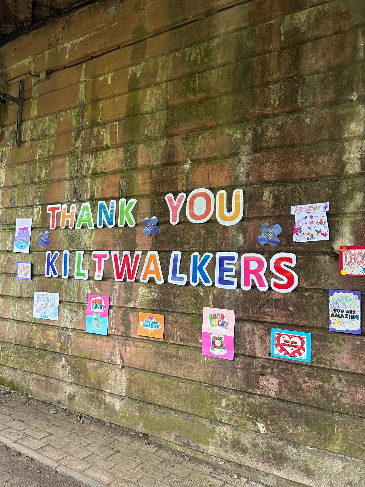 Thank you Kiltwalkers letters and children's hand-made cards displayed on a wall