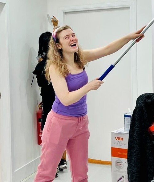 A volunteer painting a wall during a redecoration day