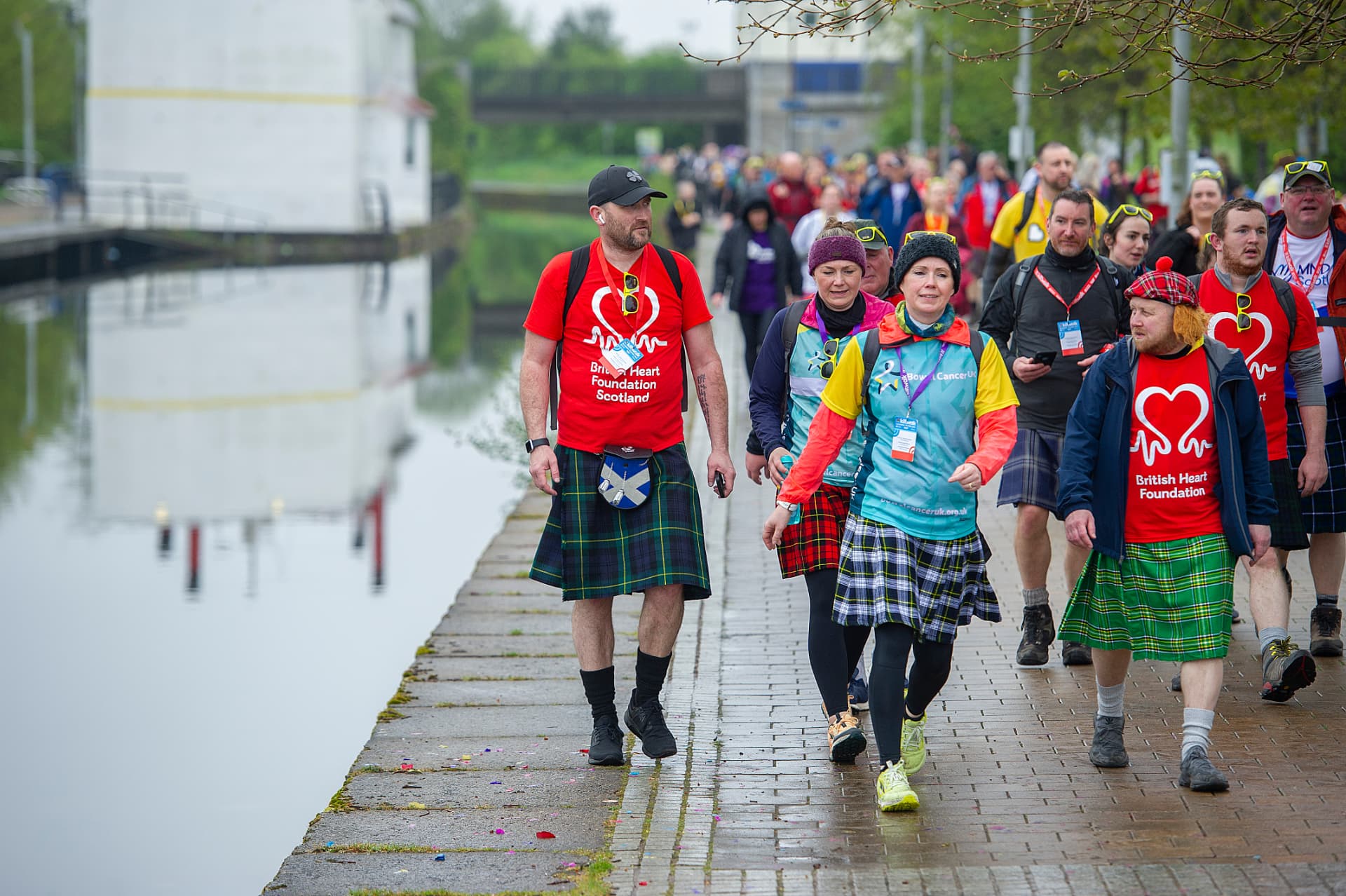 Walkers in kilts making their way along a canal path during the Kiltwalk