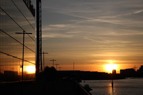 Sunset over the River Clyde reflected in a glass-fronted building