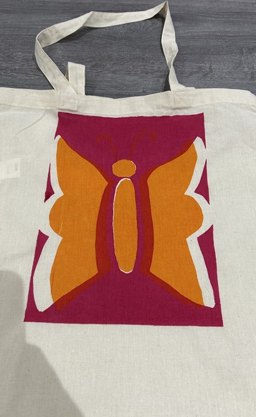 Canvas tote bag printed with an orange butterfly on a pink panel