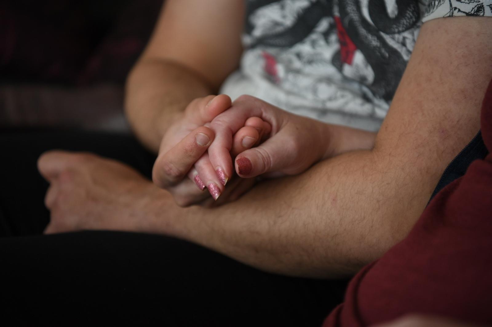 Two people holding hands in comfort