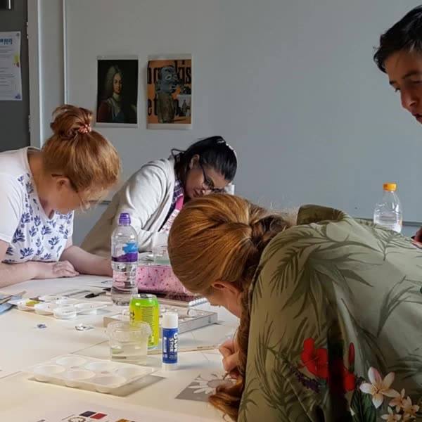 A group of learners working together on artwork during a class