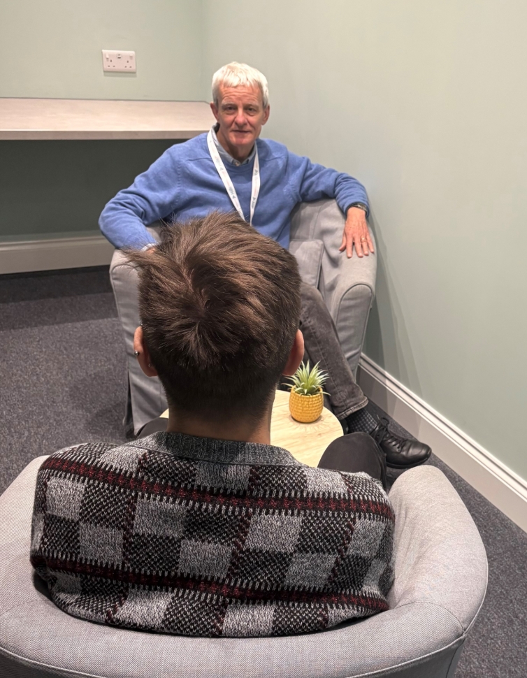 A counsellor and client talking in a quiet counselling room