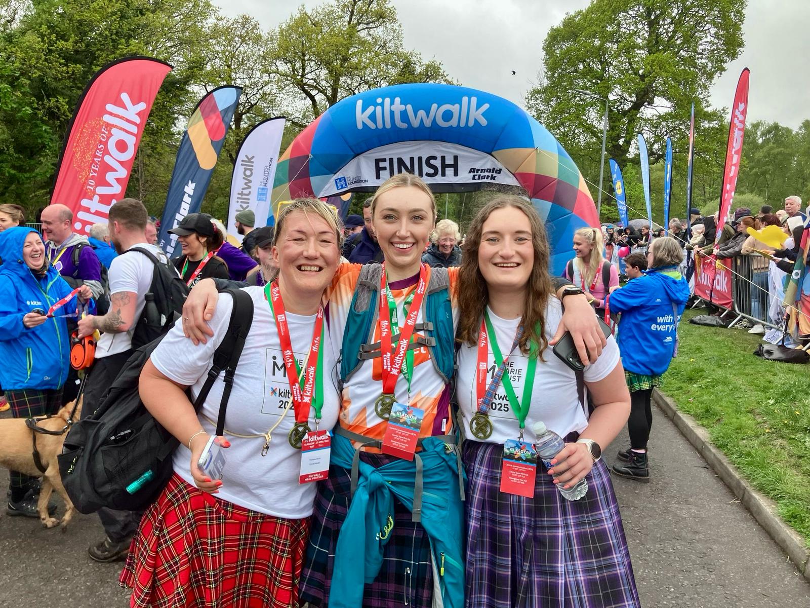 Team Marie Trust walkers celebrating with medals at the Kiltwalk finish line