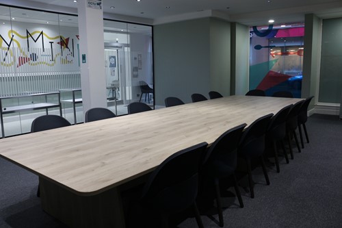 The Marie Trust education room with a long table, chairs and colourful artwork