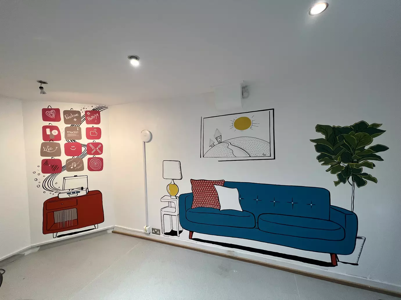 Finished wall mural of a blue sofa, record player and plant